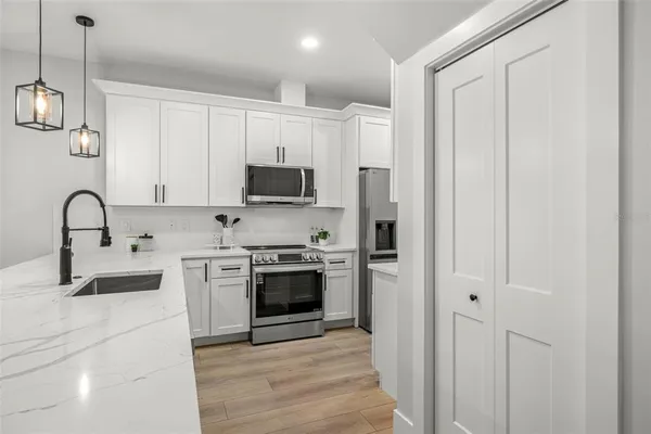 a kitchen with a sink a microwave and cabinets