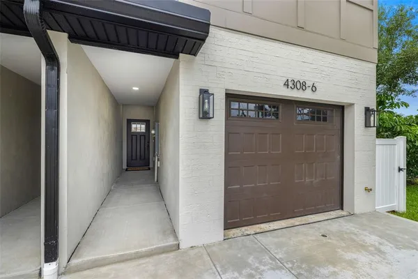 a view of a house with brick walls and a yard with plants