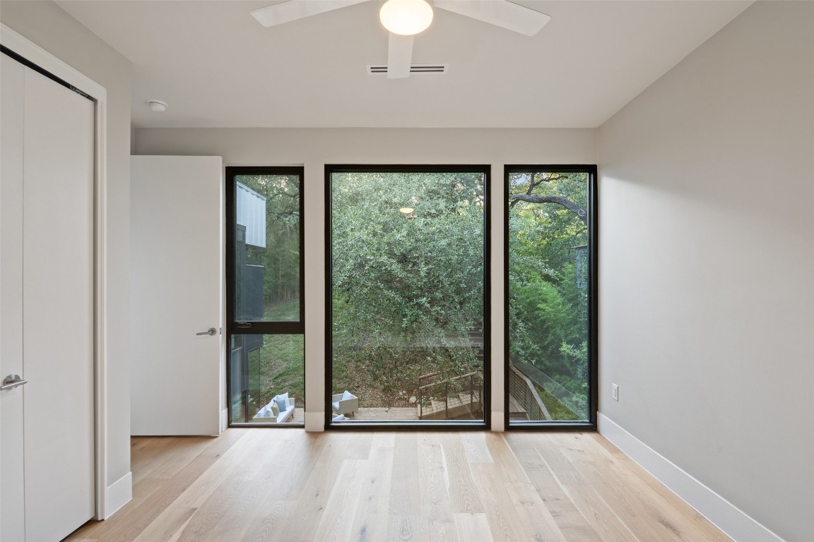 1327 Bonham Terrace, Unit B Austin, TX 78704 - Photo 27 of 40 a view of an empty room with wooden floor and a window