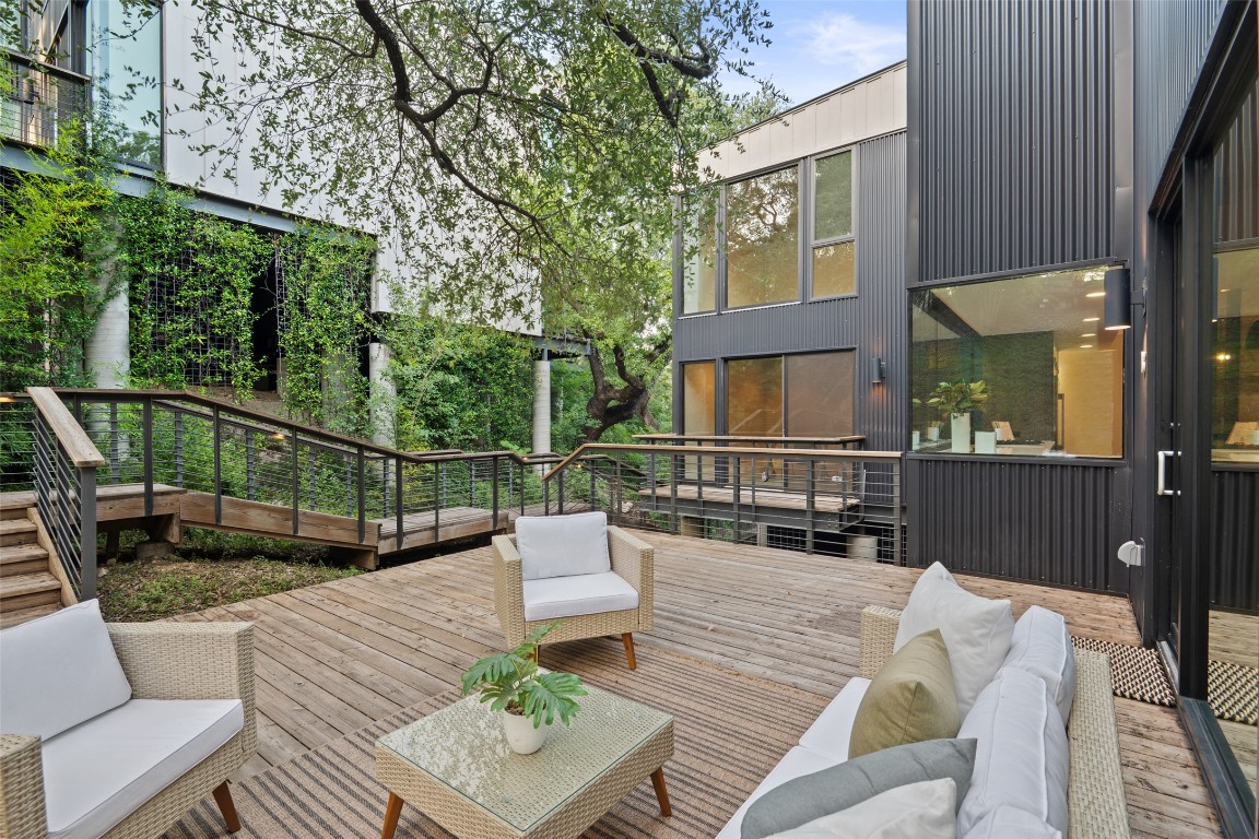 1327 Bonham Terrace, Unit B Austin, TX 78704 - Photo 3 of 40 a view of a deck with couches table and chairs with wooden floor and fence