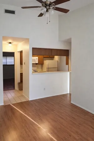a view of a room with wooden floor and a ceiling fan