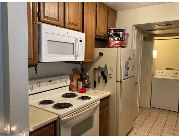 a kitchen with a sink a refrigerator and cabinets