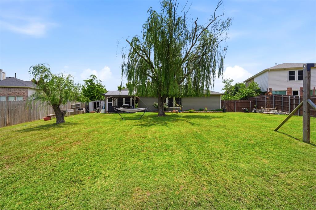 1213 Hampton Drive Forney, TX 75126 - Photo 23 of 27 a view of a backyard with a garden and trees