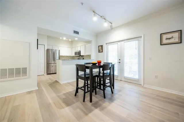 a kitchen with stainless steel appliances white cabinets and wooden floor