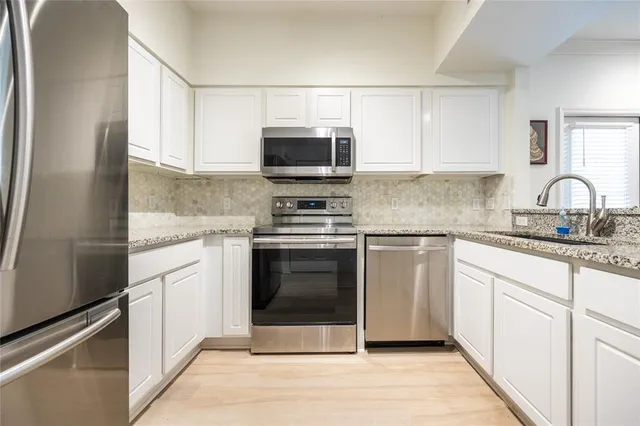 a sink with granite countertop cabinets and a sink