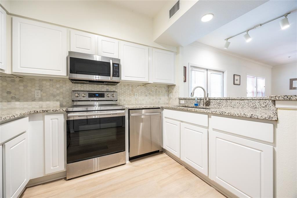 4850 Southwest 91 Terrace, Unit P201 Gainesville, FL 32608 - Photo 16 of 33 a kitchen with granite countertop white cabinets stainless steel appliances and a sink