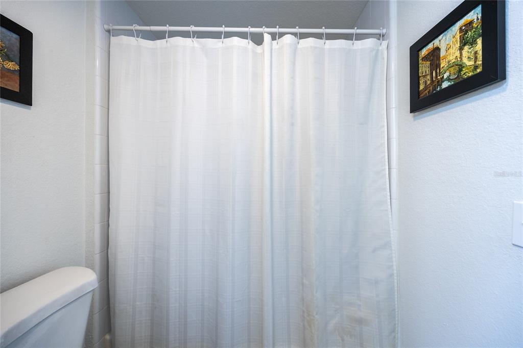 4850 Southwest 91 Terrace, Unit P201 Gainesville, FL 32608 - Photo 24 of 33 a white toilet sitting next to a shower curtain
