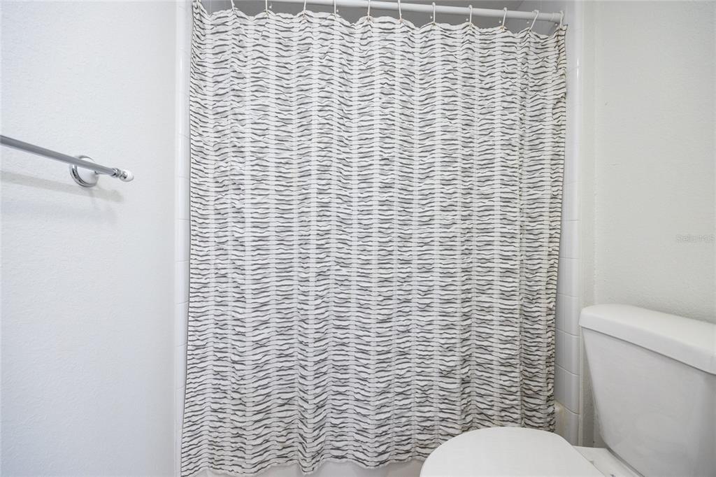 4850 Southwest 91 Terrace, Unit P201 Gainesville, FL 32608 - Photo 30 of 33 a bathroom with a toilet and a shower curtain