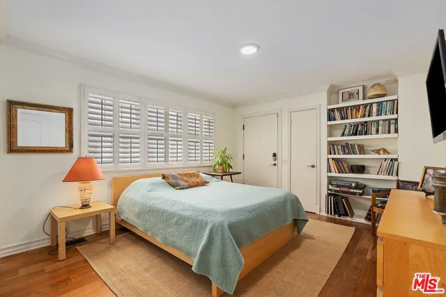 a bedroom with a bed and a book shelf