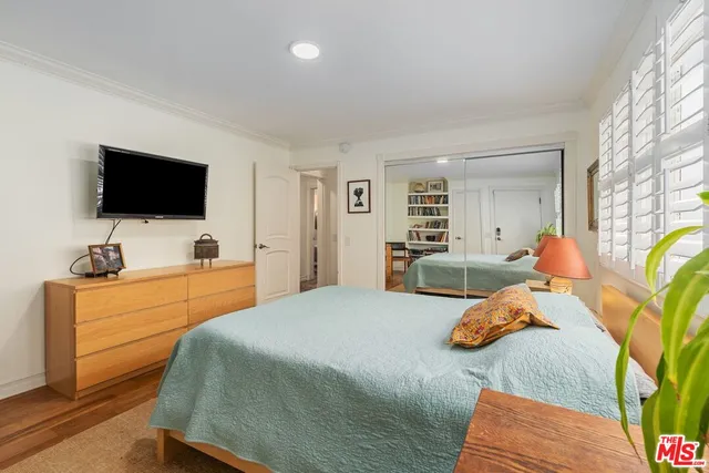 a bedroom with a bed and flat screen tv
