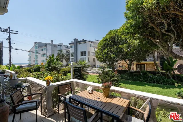 a view of a patio with table and chairs and potted plants with wooden fence