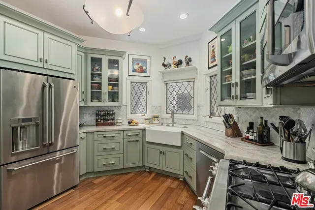 a kitchen with granite countertop a sink stainless steel appliances and cabinets