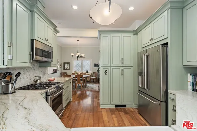 a kitchen with stainless steel appliances granite countertop a refrigerator a stove a sink and a microwave