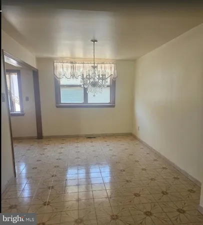 an empty room with windows and chandelier fan