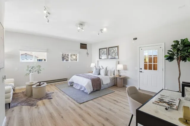 a spacious bedroom with a bed and wooden floor