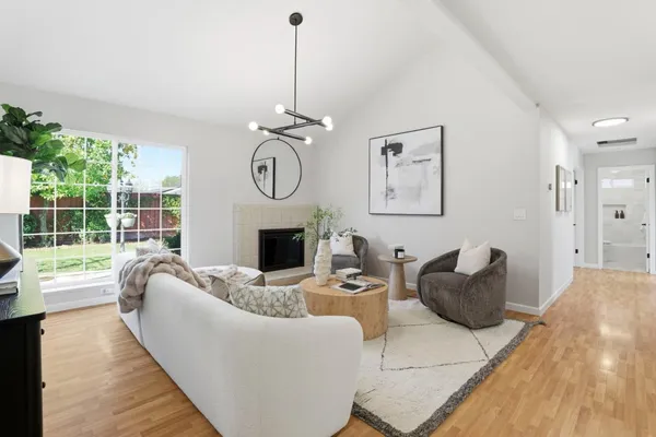 a living room with furniture a fireplace and a floor to ceiling window