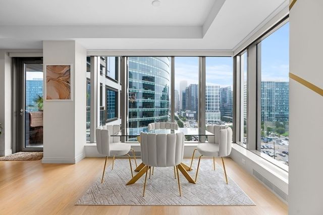 a dining room with wooden floor and glass windows
