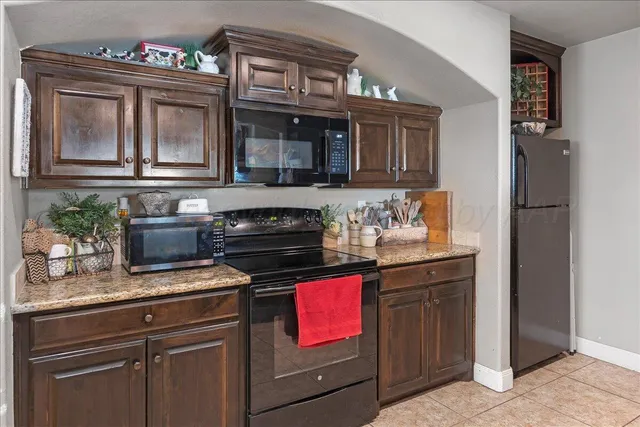 a kitchen with granite countertop a stove and a microwave