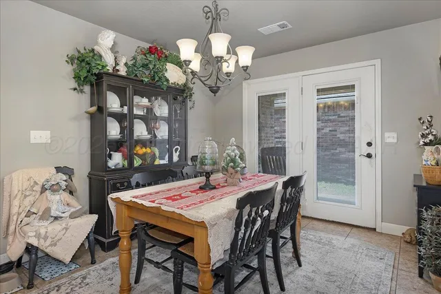 a dining room with furniture a chandelier and window