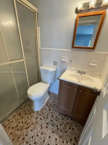 a bathroom with a sink a toilet a mirror and shower
