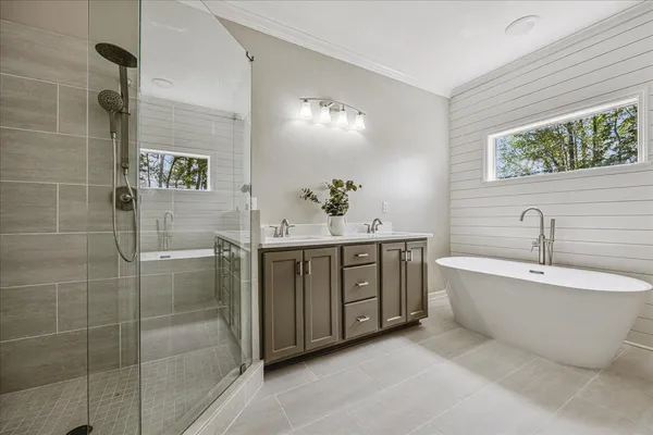 a spacious bathroom with a bathtub sink and mirror