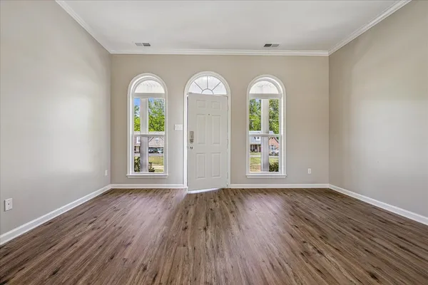 an empty room with wooden floor windows and outdoor view