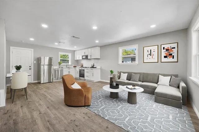 a living room with furniture and view of kitchen