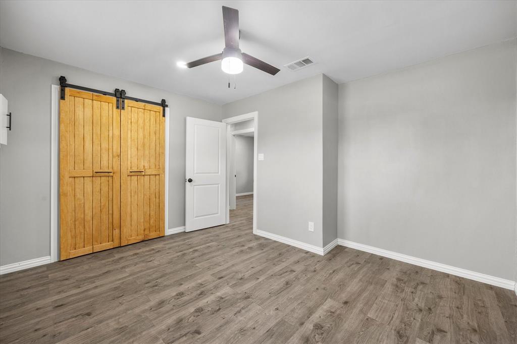 445 Canal Street Quinlan, TX 75474 - Photo 11 of 23 an empty room with wooden floor closet and windows