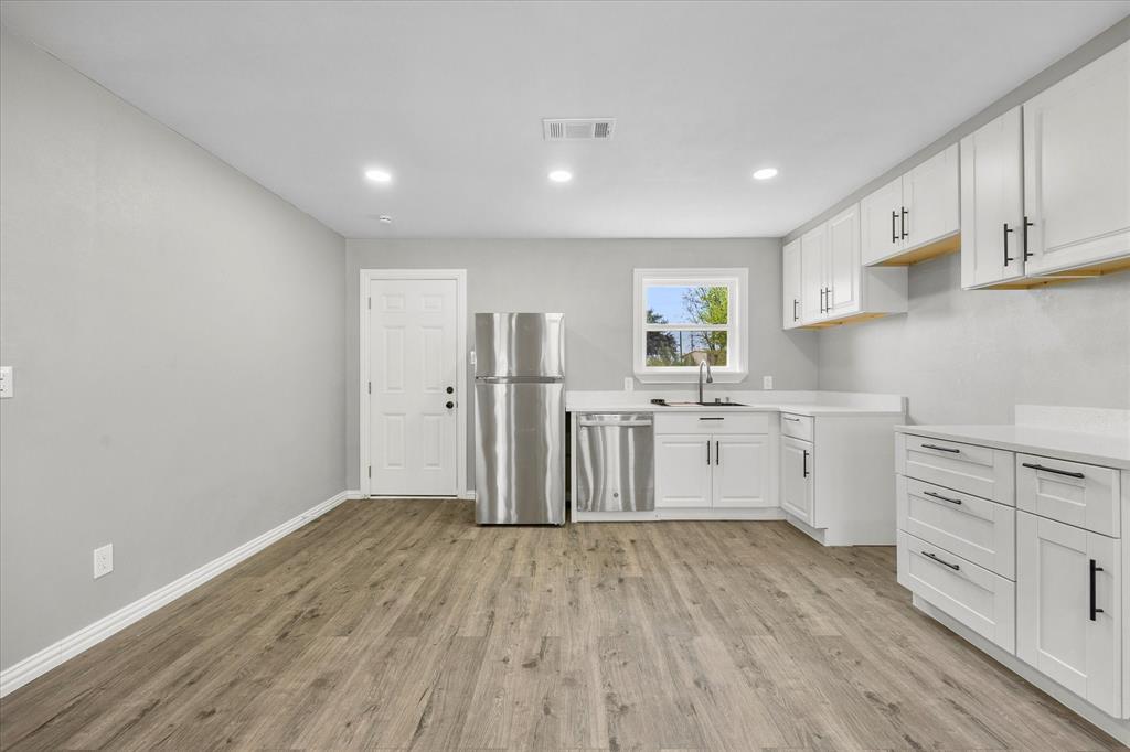 445 Canal Street Quinlan, TX 75474 - Photo 5 of 23 a kitchen with cabinets wooden floor and stainless steel appliances