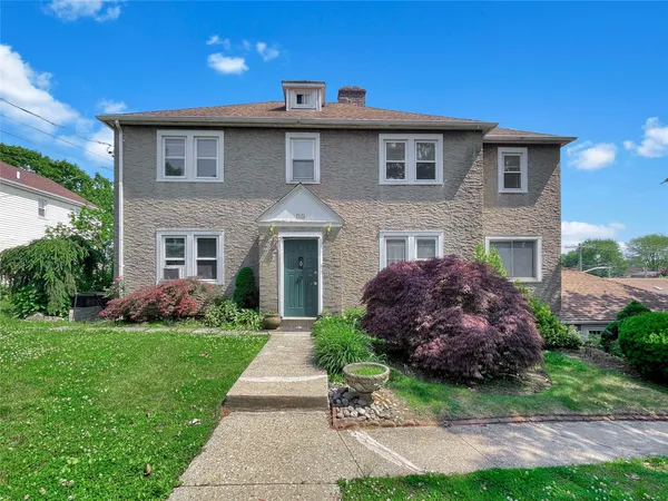 a front view of a house with a garden
