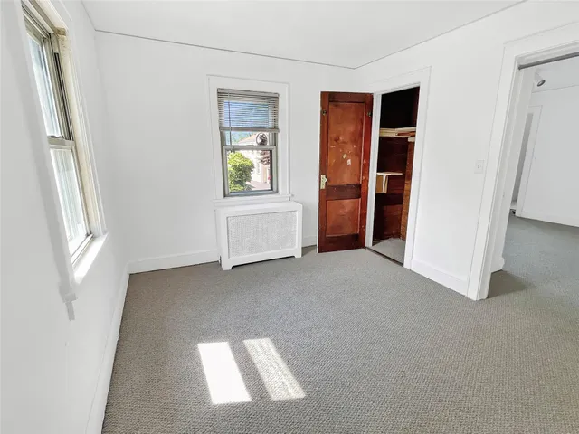 an empty room with windows and closet