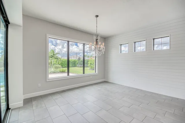 en empty room with windows and a ceiling fan