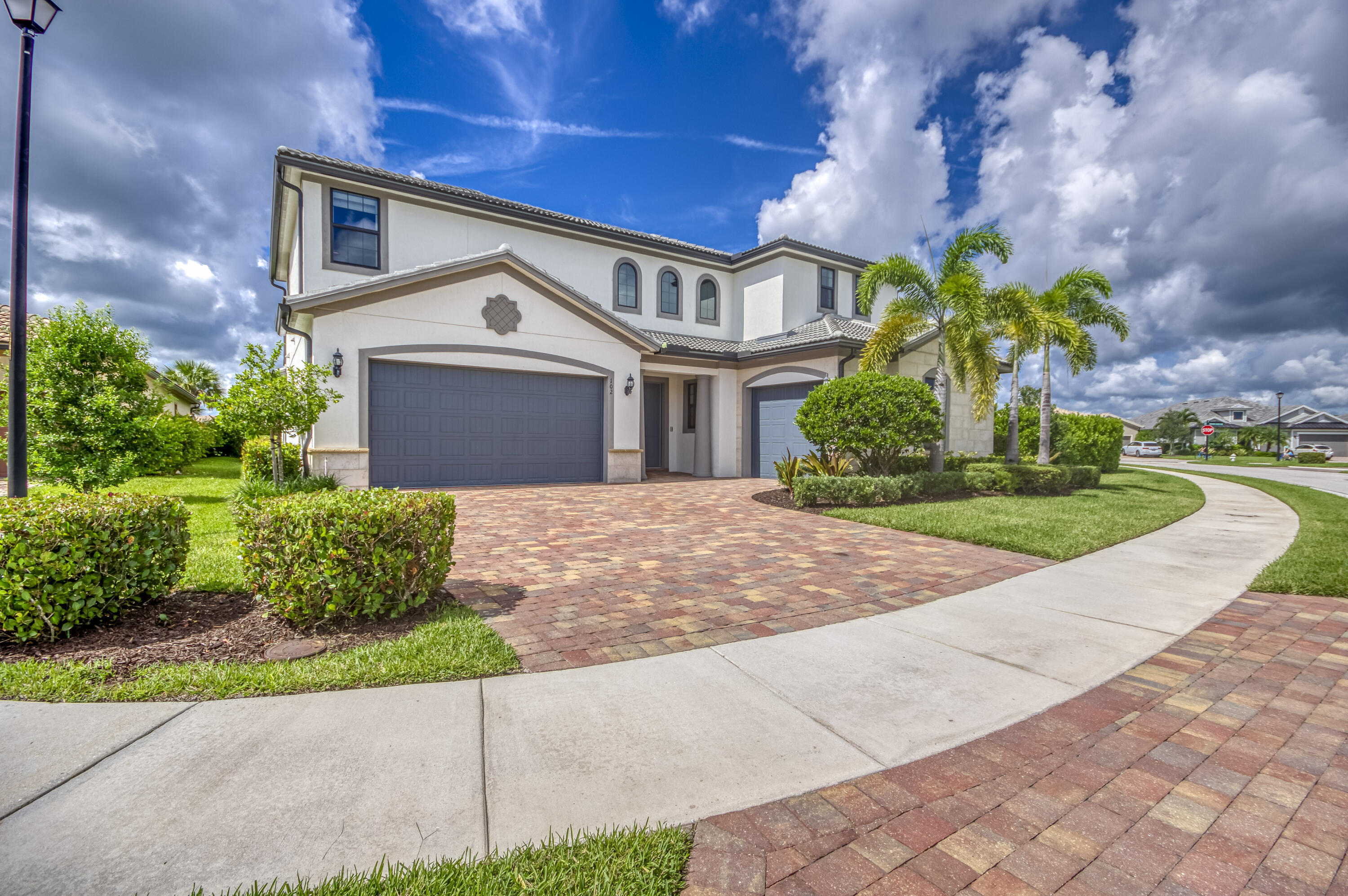 102 Cerulean Key Way Jupiter, FL 33478 - Photo 3 of 85 a front view of a house with a yard and potted plants
