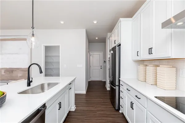 a kitchen with white cabinets and a window