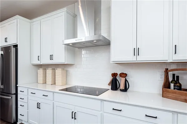 a kitchen with white cabinets stainless steel appliances and wooden floor
