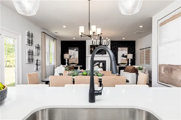 a kitchen with stainless steel appliances kitchen island granite countertop a table chairs and a refrigerator