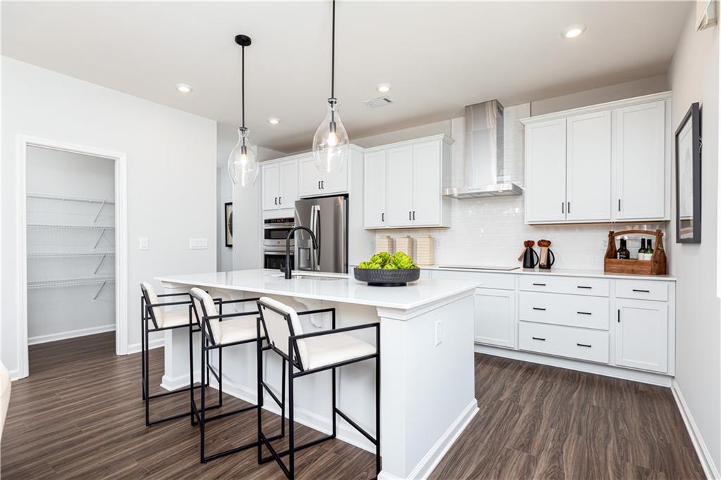 3260 Croftside Commons Powder Springs, GA 30127 - Photo 16 of 64 a kitchen with white cabinets stainless steel appliances and wooden floor