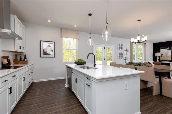 a living room with furniture kitchen view and a chandelier