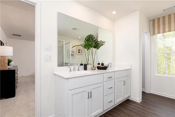 a bathroom with a granite countertop sink mirror vanity and toilet