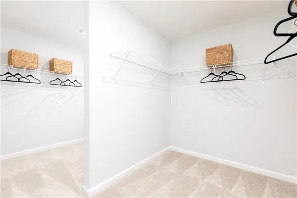 a bedroom with a bed a chandelier and a flat tv screen on dresser