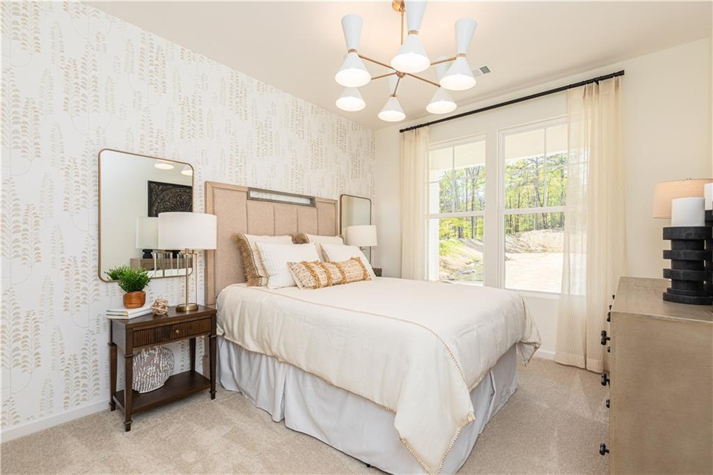 3260 Croftside Commons Powder Springs, GA 30127 - Photo 40 of 64 a bedroom with a bed a chandelier and a flat tv screen on dresser