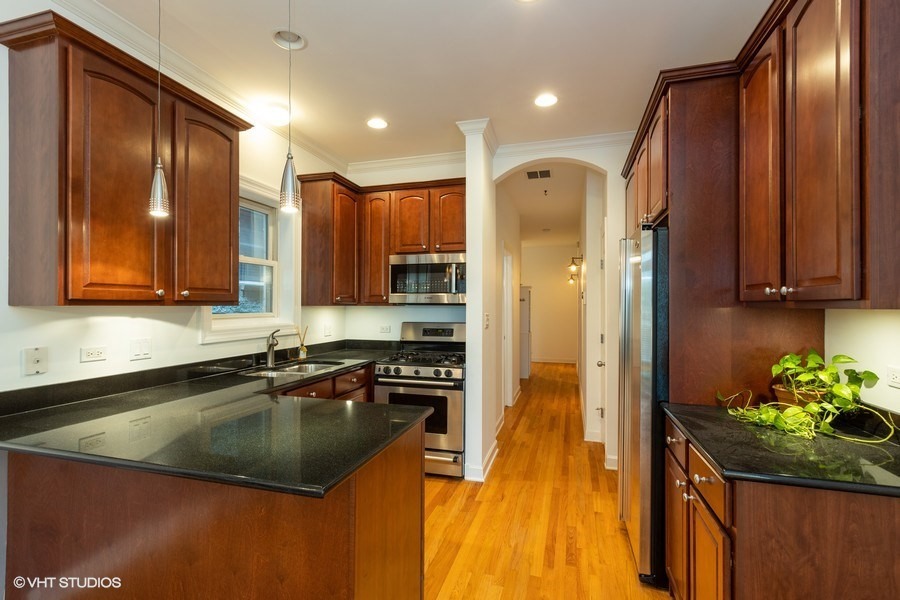 3249 North Racine Avenue, Unit 2 Chicago, IL 60657 - Photo 2 of 10 a kitchen with stainless steel appliances granite countertop a sink a stove and a refrigerator