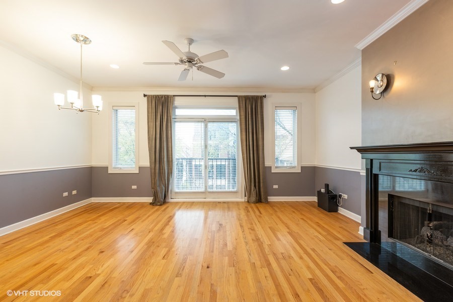3249 North Racine Avenue, Unit 2 Chicago, IL 60657 - Photo 4 of 10 a view of an empty room with wooden floor and a window