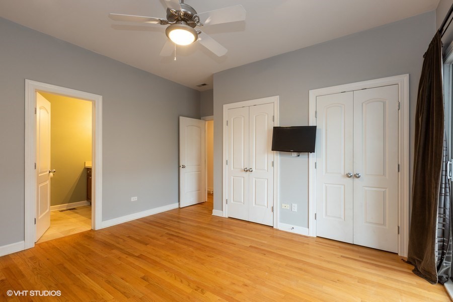 3249 North Racine Avenue, Unit 2 Chicago, IL 60657 - Photo 6 of 10 a bedroom with a bed and a chandelier