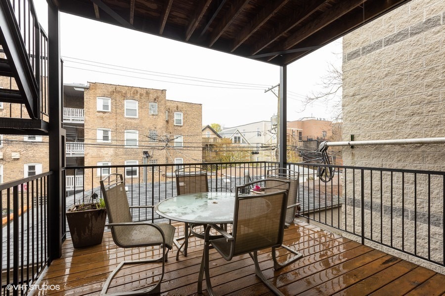 3249 North Racine Avenue, Unit 2 Chicago, IL 60657 - Photo 10 of 10 a view of a balcony with chairs and wooden floor