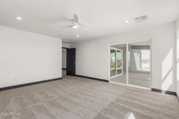 an empty room with fan and entrance