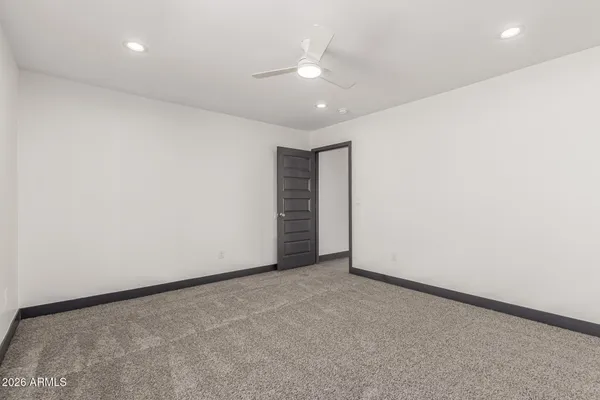 an empty room with a ceiling fan and closet