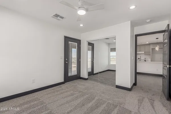 an empty room with fan and entrance