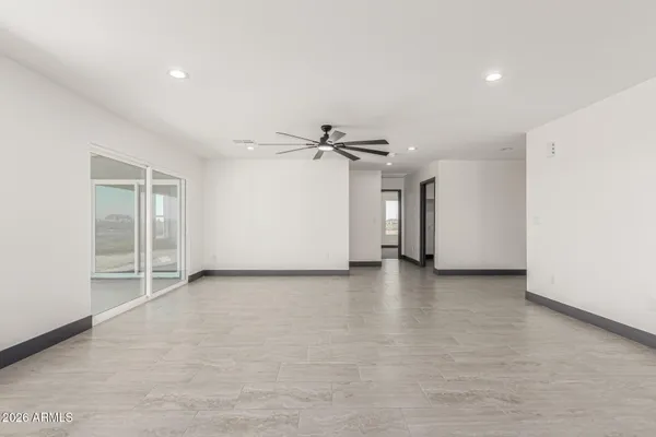 an empty room with closet and a ceiling fan