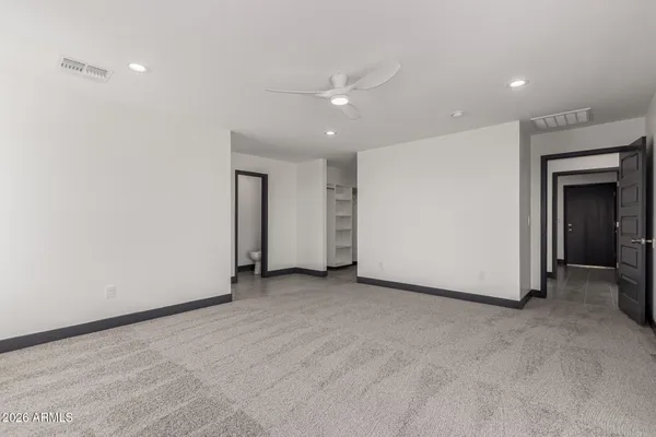 an empty room with closet and a hallway